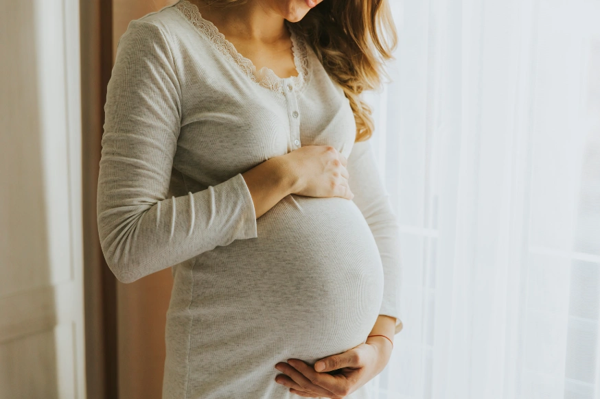 pregnant woman holding her baby