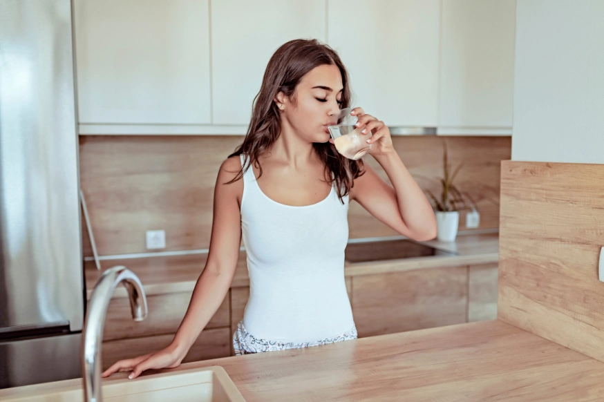 woman drinking water in the morning when she wakes up