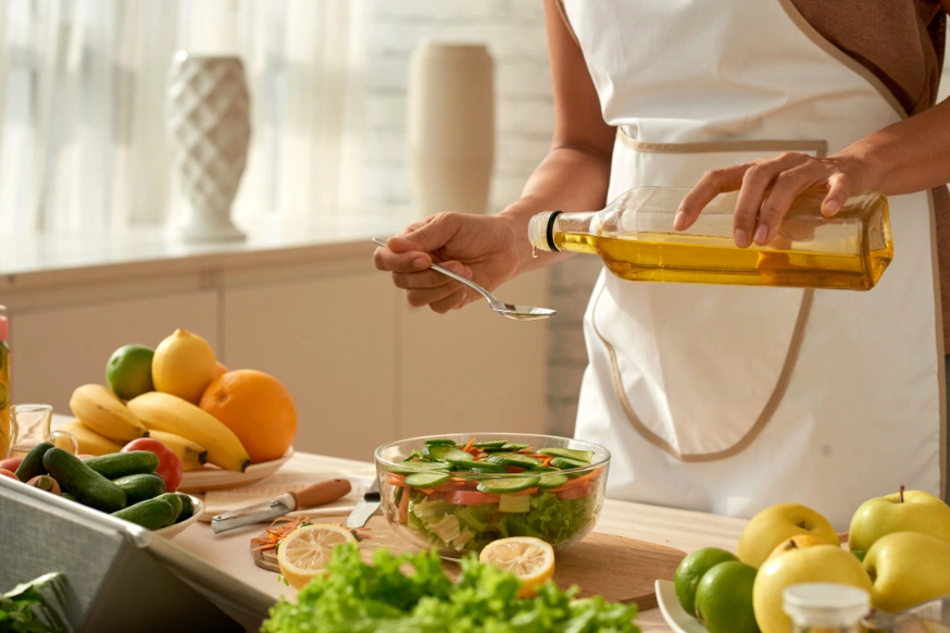 Woman making a salad dressing from olive oil